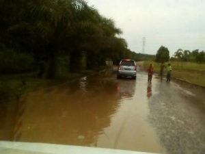 Kondisi Genangan Air di Jalan Lingkar Banyuasin Mulai Dimanfaatkan Pak Ogah